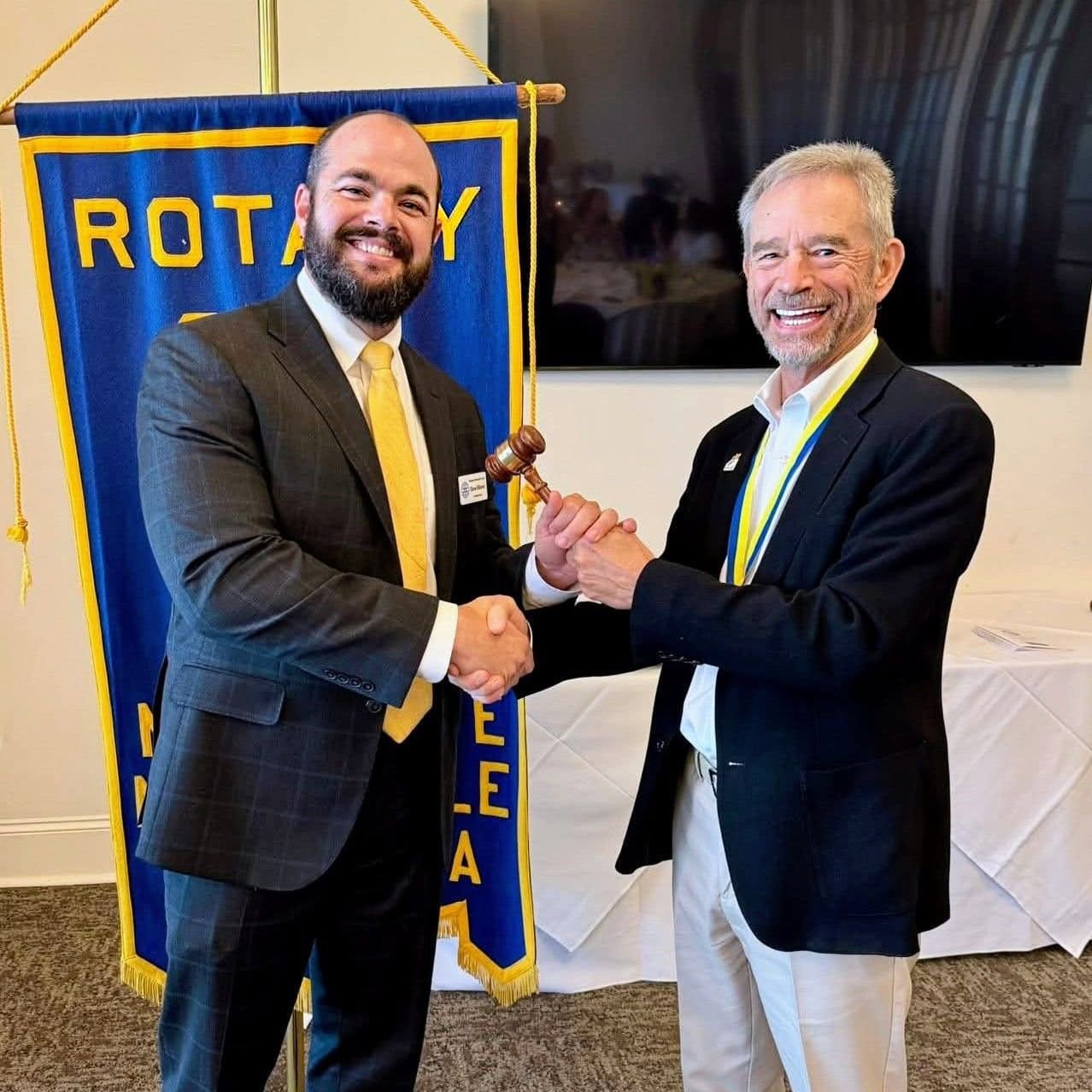 Chase Villeret receiving the gavel after being inducted as the President of Northlake-Mandeville Rotary Club.